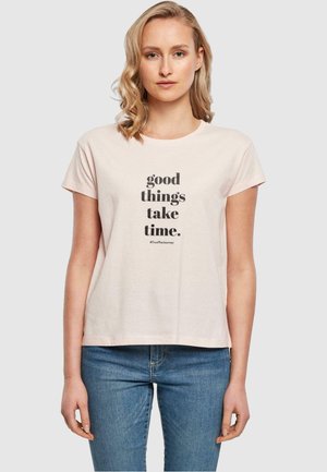 Light pink cotton t-shirt with short sleeves and round neckline. Features black text that reads "good things take time." #TrustTheJourney.