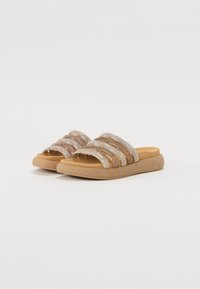 Des sandales à enfiler avec de larges bandes en tissu à rayures métalliques dorées et argentées, dotées d'une semelle en caoutchouc marron durable pour plus de confort.