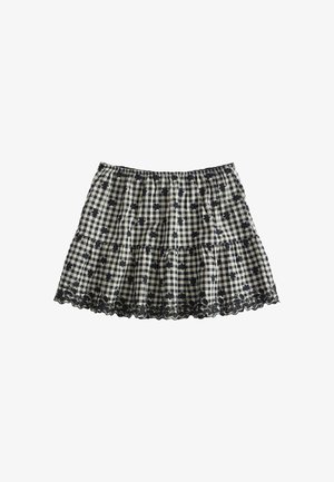 Zwart-witte geruite rok met kleine zwarte bloemenprints en kanten rand langs de onderkant, elastische tailleband en geplooide stof.