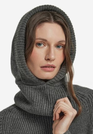 Grå stickad tröja med ribbad struktur och en stor huva. Närbild visar det mjuka tyget och det invecklade stickmönstret.