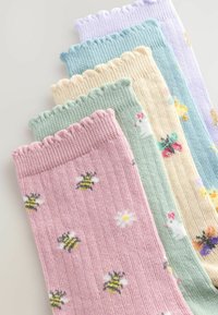 Ensemble de cinq chaussettes tricotées dans des couleurs pastel : rose avec des abeilles, vert avec des fleurs, jaune avec de petits motifs et violet clair. Bords festonnés.