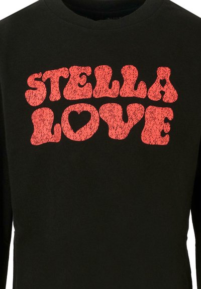 Camicia nera in cotone a maniche lunghe con lettering retro in grassetto rosso, testurizzato, che mostra "STELLA LOVE" e una grafica di un cuore.