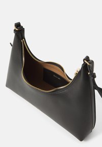 Borsa a tracolla in pelle nera con design curvo, cerniera dorata e interno marrone. Include una tasca per carte. Tracolla regolabile.