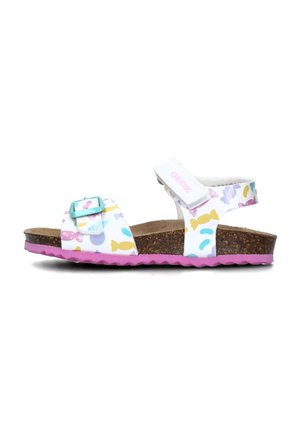 Sandalias blancas con un patrón colorido de peces y formas, correa ajustable, plantilla de corcho y suela de goma rosa. Nombre de la marca "GEOX" visible.