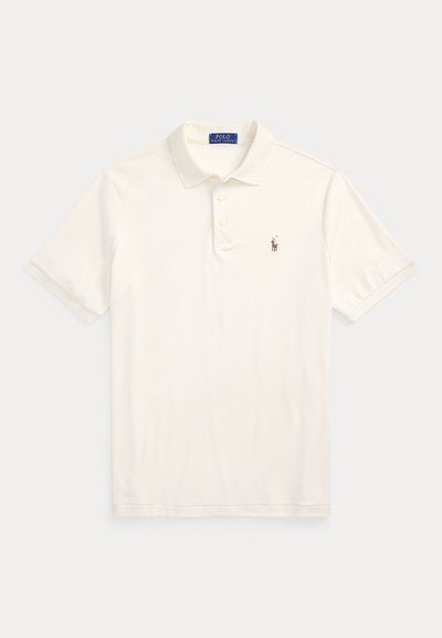 Balts īss piedurkņu polo krekls ar apkakli, trim pogām un mazu izšūtu Polo Ralph Lauren logotipu kreisajā krūšu pusē.