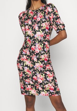 Sort knælange kjole til kvinder med pufærmer i kort længde og rød, pink og lilla blomsterprint, båret af en stående model.