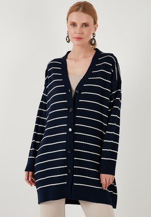 Navy cardigan featuring white horizontal stripes, ribbed texture, V-neck, and large buttons, with long sleeves and a relaxed fit.