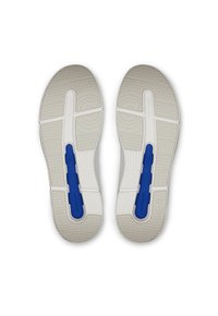 Baskets de sport blanches avec une semelle texturée, présentant des accents bleus sur la semelle et des motifs de traction distincts. Fini en matériau lisse.