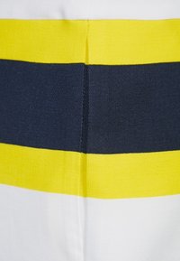 Tkanina s pruhy v bílé, žluté a námořnické modři. Textura je hladká, s výraznými, rovnoměrnými vodorovnými pruhy.
