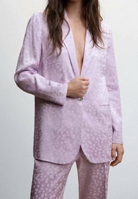 Lavender corduroy suit with a textured dotted pattern. Features a single-button closure, notched lapels, and side pockets.