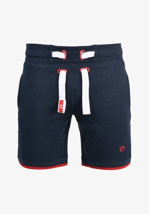 Tamsiai mėlynos sportinės šortai, pagaminti iš minkštos medžiagos, su baltais ir raudonais raišteliais, raudona detalė apatinėje dalyje ir logotipu ant blauzdos.