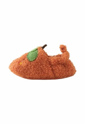 Soft, orange, curly-textured baby shoe shaped like a pumpkin with a green leaf and small brown stem detail.