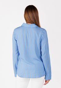Blauw-wit gestreepte blouse met een kraag, lange mouwen en een afgeronde zoom. Glad stof met verticale strepen en een klassiek ontwerp.