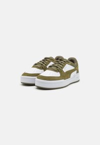 Green suede sneakers with white leather accents. Features a perforated toe box, flat laces, and a thick white sole.