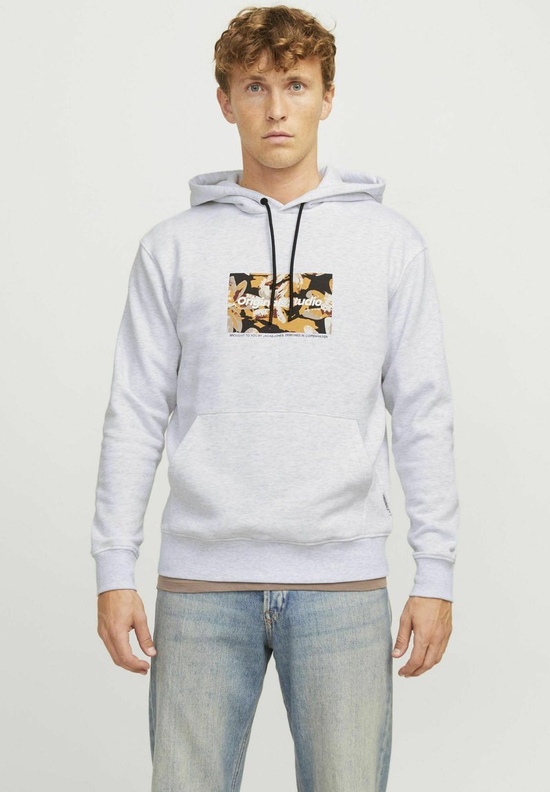Lichtgrijze pull-over hoodie van een zachte stof, met een centraal grafisch logo in zwart en oranje. Verstelbare trekkoordkap, kangoeroezak.