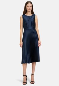 Navyblaues Satinkleid mit tailliertem Oberteil, plissiertem A-Linien-Rock und einem Taillengürtel. Verfügt über einen runden Halsausschnitt und ein ärmelloses Design.
