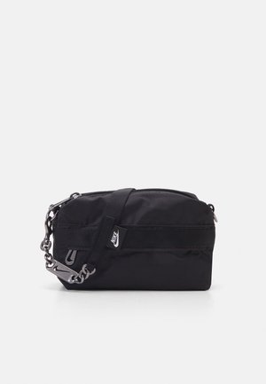 Sort Nike crossbody taske med lynlås, justerbar rem med metalled og lille hvid Nike-logo tag foran.
