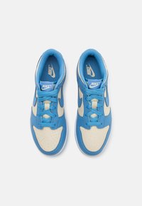 Nike sportbačiai su mėlynu odiniu viršumi, smėlio spalvos detalėmis, perforuota pirštų dalimi ir mėlynomis raištelėmis. Vidpadžiai puikuojasi Nike logotipu.