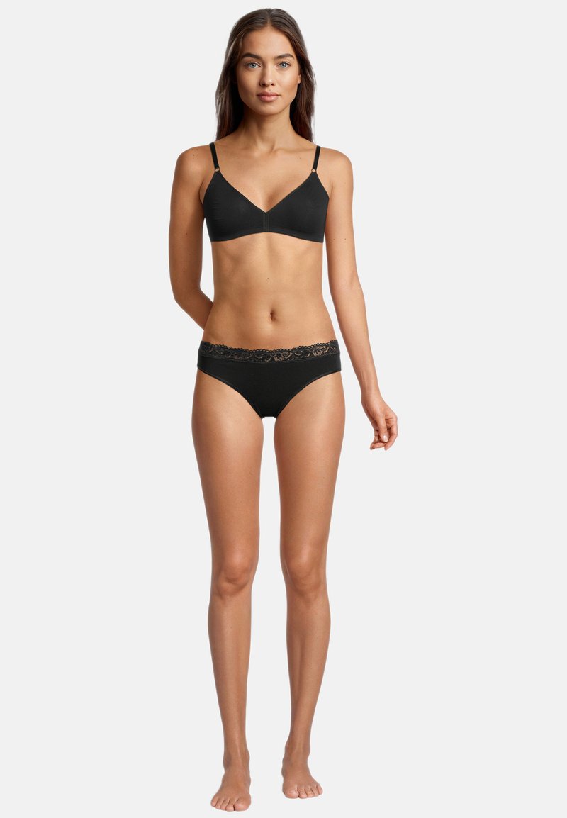 Schwarzer Bralette mit verstellbaren Trägern; passende schwarze Panties mit eleganter Spitzenkante am Bund. Glattes Material, schlichtes Design.