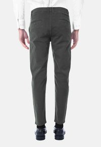 Chinos grigio scuro con vestibilità slim, caratterizzati da una texture di cotone liscia, tasche posteriori e un dettaglio standard in vita.