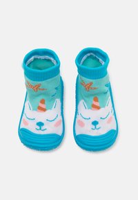 Aqua-blaue Knöchelsocken mit strukturierten Gummisohlen, die ein lächelndes Einhorn-Design mit einem pinken Horn und bunten Seesternelementen zeigt.