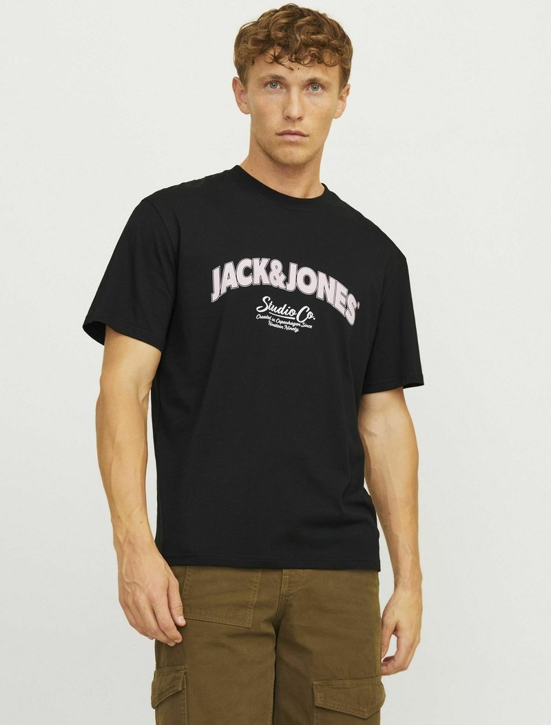 Sort bomulds t-shirt med "JACK & JONES" i pink skrift. Kortærmet og med crew neck design, parret med beige cargo bukser.
