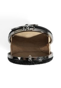 Pochette noire avec une surface texturée, cadre en métal et fermeture à clip. Intérieur en tissu beige, avec espace pour petits objets.