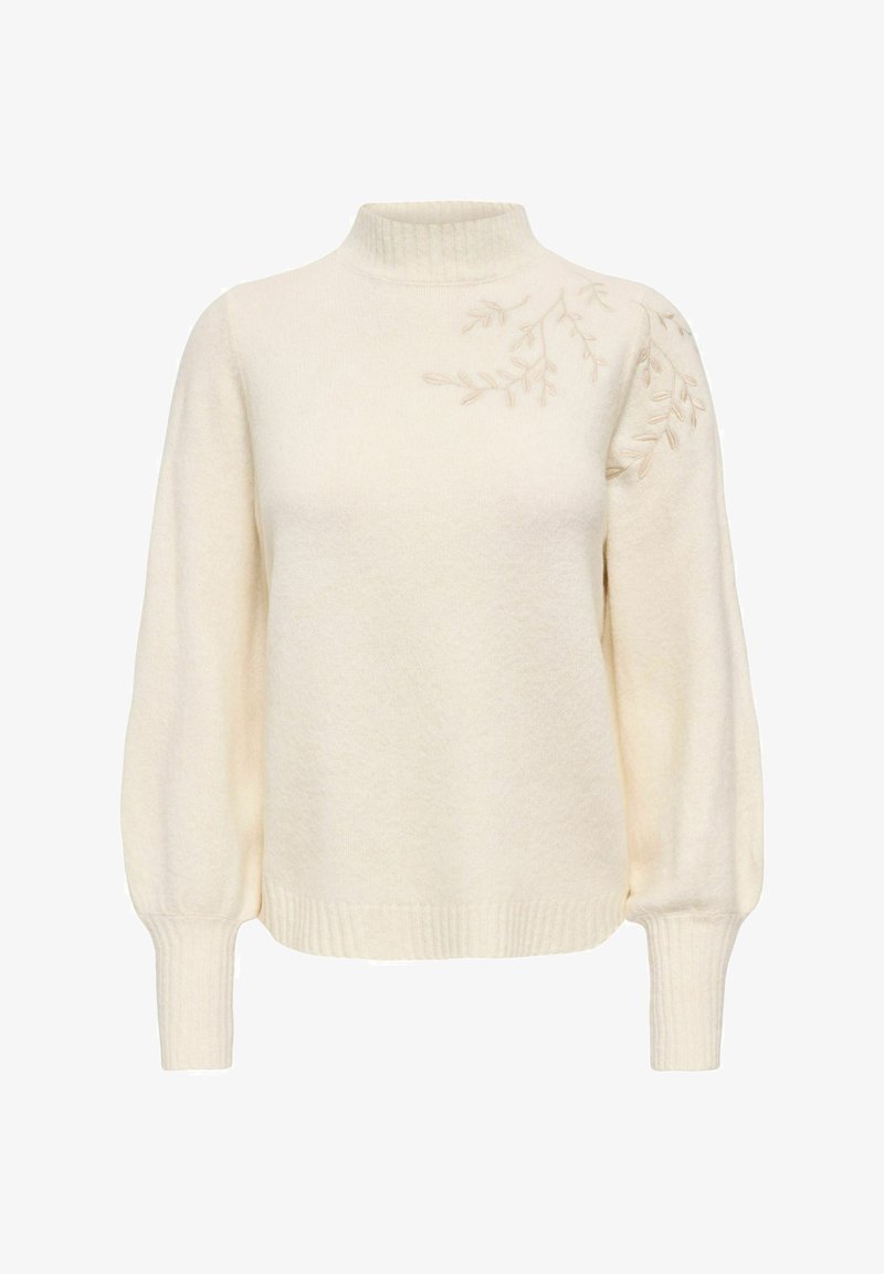 Pull en maille couleur crème à manches longues, col montant et poignets côtelés, avec une discrète broderie de feuilles sur l'épaule droite.