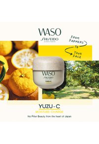 Pot de crème hydratante WASO Shiseido Yuzu-C avec des fruits yuzu et un fond de verger, mettant en avant les ingrédients naturels et les bienfaits pour la peau.