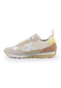 Retro sneakers with a beige and tan suede and synthetic upper, white accents, a yellow heel tab, and textured laces on a rubber outsole.
