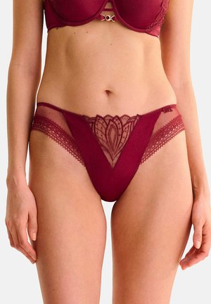 Lingerie bordeaux avec une découpe en forme de V, ornée de détails en dentelle et d'accents en maille. Bord texturé le long de la taille et du dos.