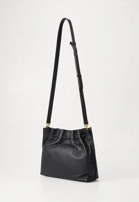 Borsa in pelle nera con un design morbido e arricciato, tracolla regolabile e dettagli in oro. Presenta una forma rotonda e strutturata.
