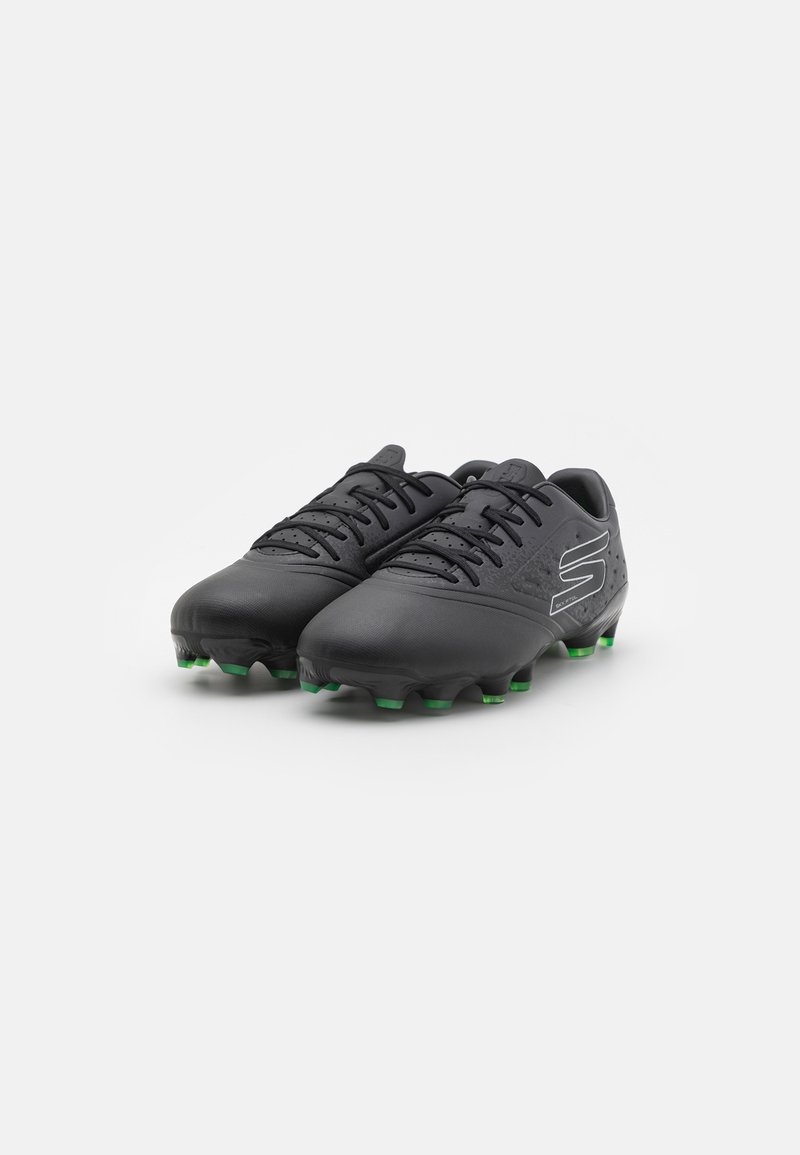 Ghete de fotbal negre cu partea superioară dintr-un material sintetic texturat, cu știfturi verzi și un design cu șireturi. Prezintă un logo pe partea exterioară și detalii perforate.