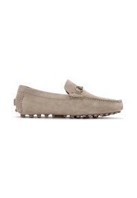 Zapatos estilo mocasín de ante beige con suela plana, costuras decorativas y un pequeño acento en la parte superior. Diseño ligero y flexible.