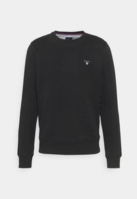 Felpa nera in cotone, con collo rotondo, maniche lunghe, polsini e orlo a coste, e un piccolo logo sul petto.