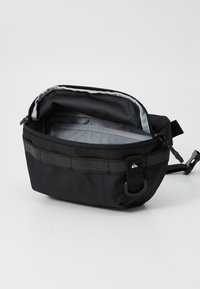 Černá Messenger taška se zipem, šedým interiérem a vnějšími popruhy. Má obdélníkový tvar a je vyrobena z odolného materiálu.