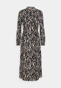 Långärmad klänning i svart och krämfärgad abstrakt mönster, med ett intillåst midja och rak passform, tillverkad av mjukt, texturerat tyg.