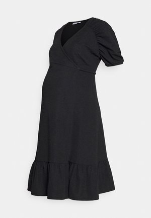 Vestido de maternidade preto com um design envolvente, mangas curtas com volume e uma bainha com babados. O tecido texturizado acrescenta profundidade à cor sólida.