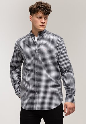 Czarna i biała koszula w kratkę z guzikami, z kieszonką na piersi, zaokrąglonym dołem i długimi rękawami, wykonana z gładkiej bawełny.