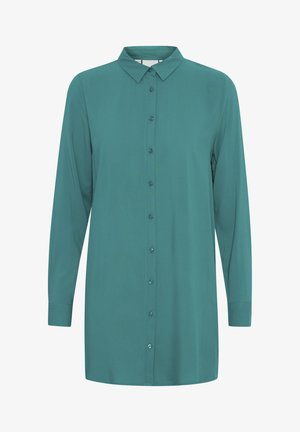 Mėlynas mygtukais užsegamas marškinėliai su ilgomis rankovėmis, apykakle ir priekiniais užsegimais. Pagaminta iš lygaus audinio tiesiai supjaustytų ir be raštų.