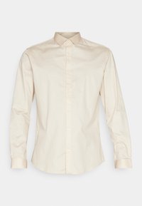 Beige button-up shirt with a sleek collar, long sleeves, and smooth texture. Features a rounded hem and subtle sheen on cuffs and collar.