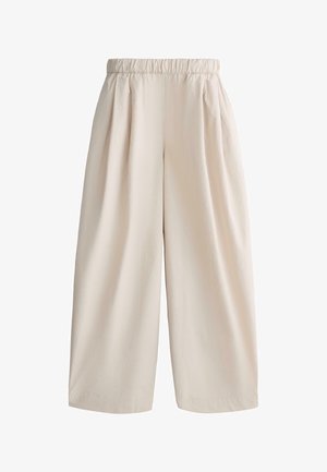 Béžové široké nohavice s elastickým pásom a záhybmi, vyrobené z ľahkej látky, vhodné na bežné alebo formálne nosenie.