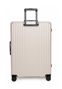 Valigia rigida beige con scanalature verticali, manico telescopico esteso, manico laterale e quattro ruote girevoli nere su sfondo bianco.