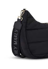 Schwarze, gesteppte Umhängetasche mit runder Form, Hardware in Golddetails und einem strukturierten schwarzen Tragegurt mit dem Text "HEY MARLY."