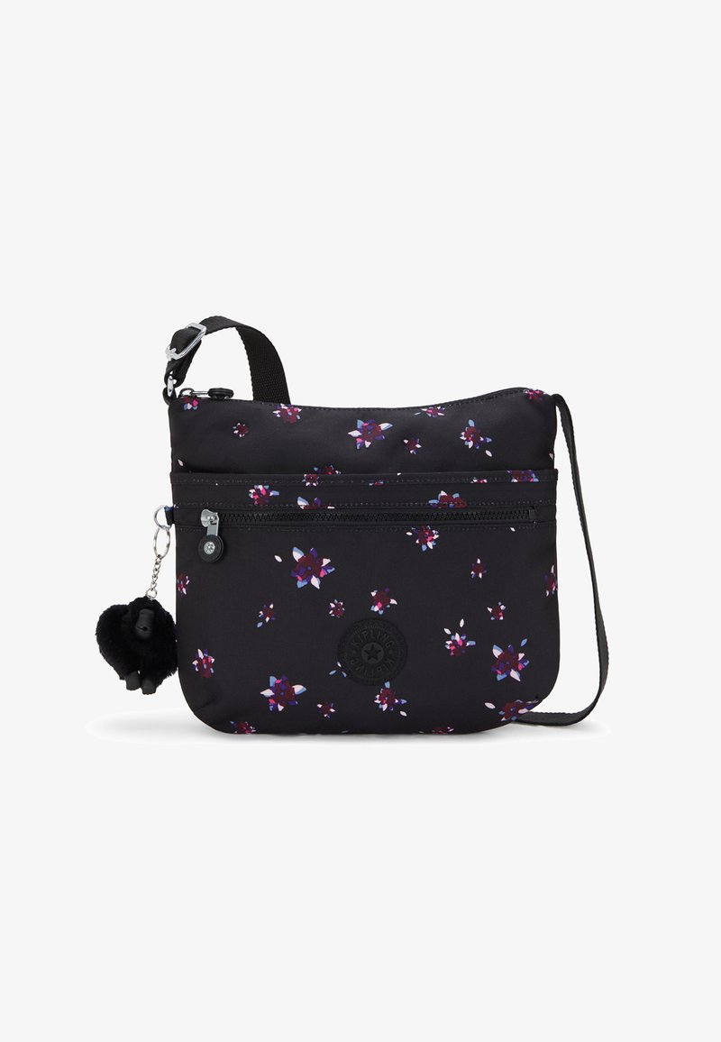 Borsa a tracolla nera in tessuto con stampa floreale in viola e rosa. Presenta una tasca con zip, una toppa con logo e un ciondolo pom-pom nero.