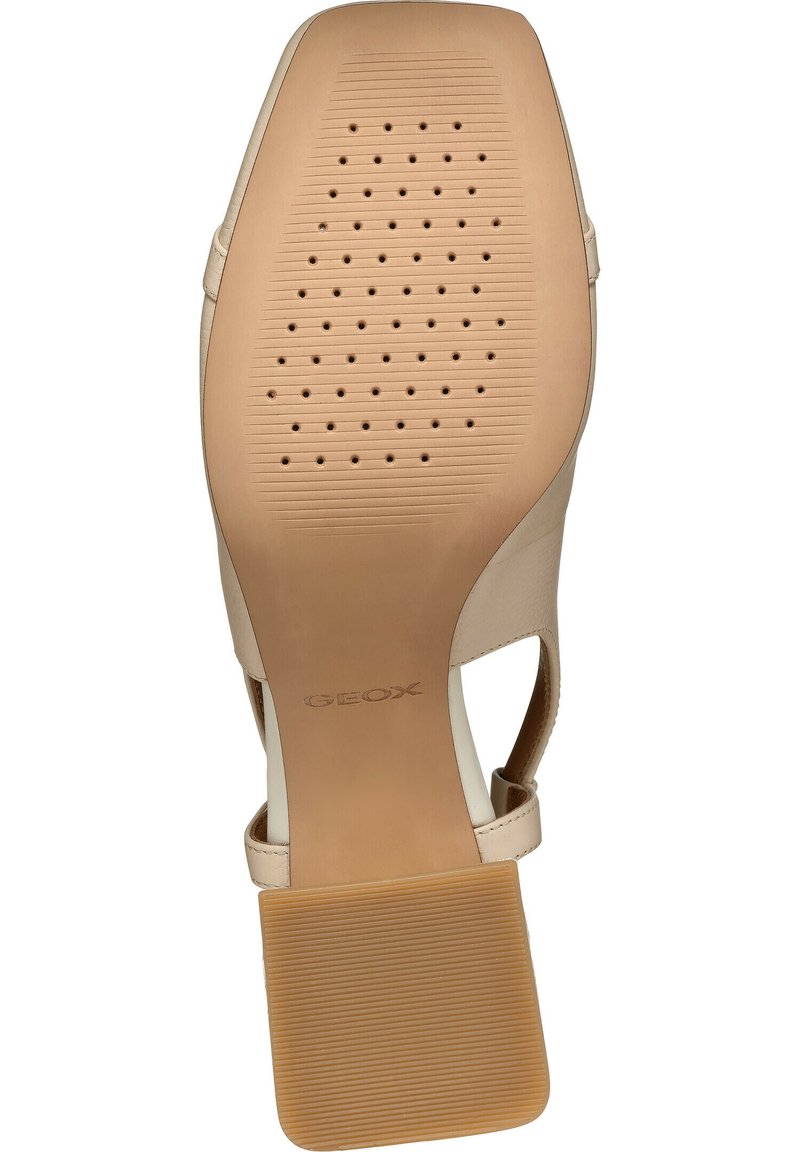Sandale à talons hauts beige avec une tige en cuir lisse, des côtés ouverts et une semelle en caoutchouc comportant des perforations et un motif texturé pour une meilleure adhérence.