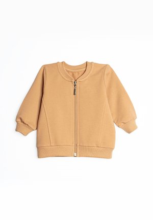 Lekko brązowa kurtka niemowlęca z długim rękawem, z prążkowanymi mankietami, kołnierzem i dolnym obszyciem, z zamkiem błyskawicznym z przodu na białym tle.