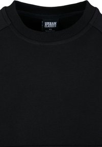 Black sweatshirt with a round neckline, featuring a soft texture, ribbed cuffs, and a label reading "URBAN CLASSICS" in white.