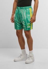 Grønne mønstrede shorts med en gul sidelinje og logo-patch, med en elastisk talje og letvægtsmateriale.