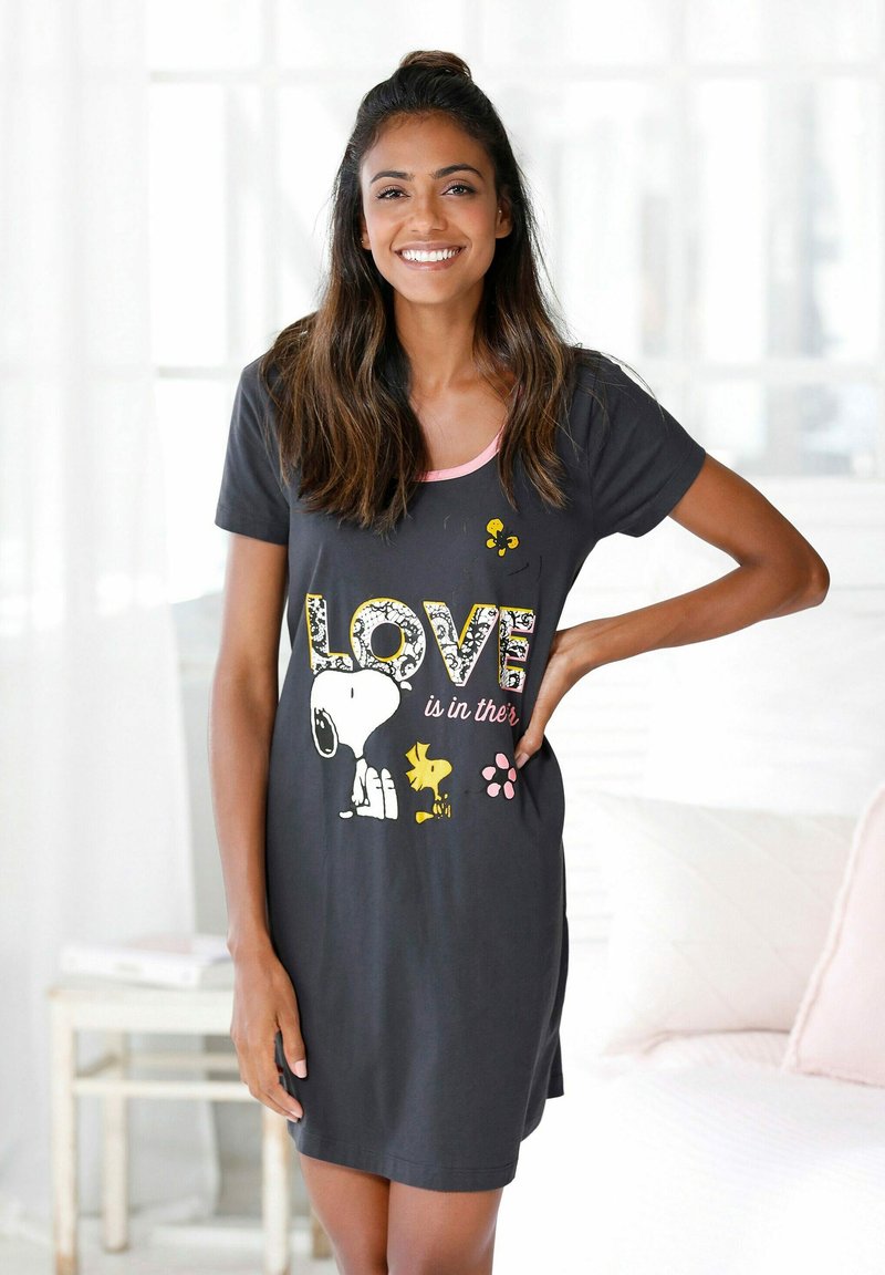 Cotton nightshirt in black with a pink neckline. Features a graphic print of Snoopy and friends, with the text "LOVE is in ther’s."
